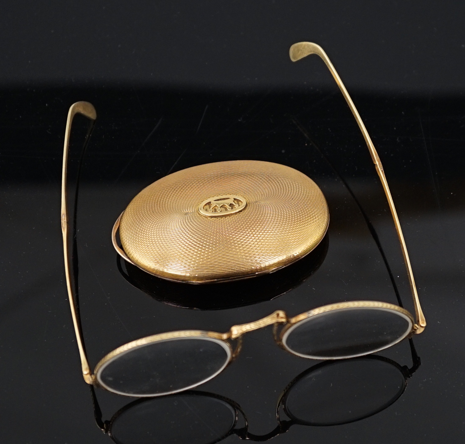 A pair of engraved gold mounted spectacles